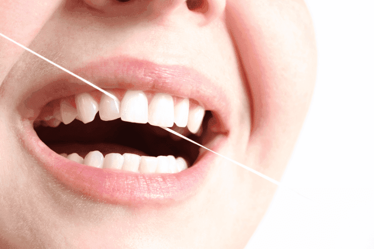 Dental floss used between teeth during oral care.